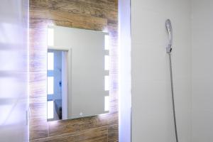 a mirror on a wall in a bathroom at Birdhouse Apartments in Prešov +9 photos