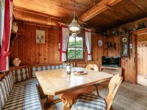 a dining room with a wooden table and chairs at Weberhäusl am Penningberg in Hopfgarten im Brixental