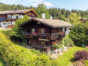 a large wooden house on a hill with trees at Weberhäusl am Penningberg in Hopfgarten im Brixental
