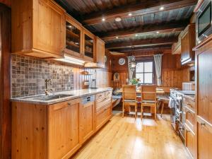 a kitchen with wooden cabinets and a dining room at Weberhäusl am Penningberg in Hopfgarten im Brixental