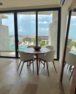 a table and chairs in a room with a large window at Stylish 1BR Ocean View near 5th Ave in Playa del Carmen