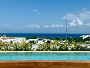 a swimming pool with a view of the ocean at Stylish 1BR Ocean View near 5th Ave in Playa del Carmen