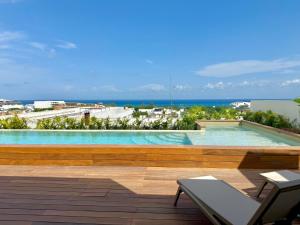 a swimming pool with a view of the ocean at Stylish 1BR Ocean View near 5th Ave in Playa del Carmen