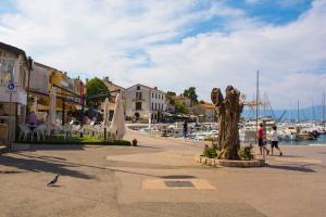 a group of people walking around a harbor with boats at Apartment Malinska 44 in Malinska