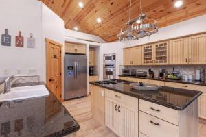 a large kitchen with a sink and a refrigerator at Hillside Hideaway - game rm - master spa - Luxury in Lake Arrowhead