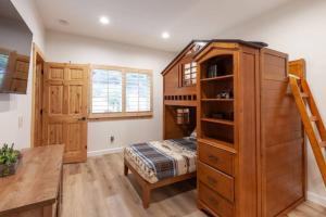 a bedroom with a bunk bed and a wooden cabinet at Hillside Hideaway - game rm - master spa - Luxury in Lake Arrowhead