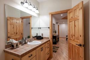 a bathroom with a sink and a large mirror at Hillside Hideaway - game rm - master spa - Luxury in Lake Arrowhead +37 photos