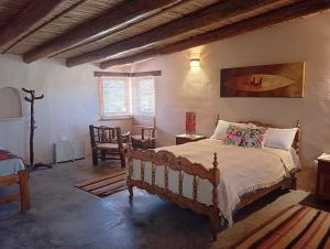 a bedroom with a bed and a table and chairs at Sendero De Las Cabras in Purmamarca