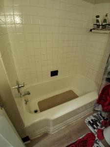 a bath tub in a bathroom with a tiled wall at GA home in Milwaukee