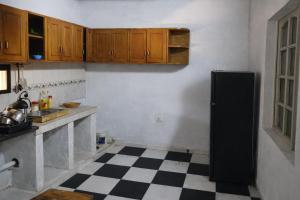 a kitchen with a black refrigerator and a checkered floor at La Petite Maison Mariano Casa in Limpio +13 photos