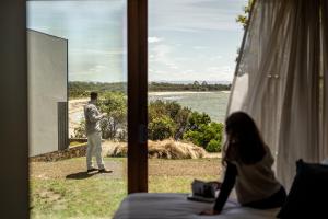 a man standing outside a window looking out at a woman at Piermont Retreat in Swansea