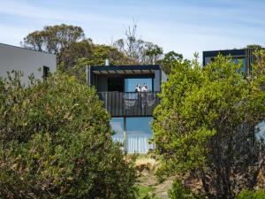 people on the balcony of a house with trees at Piermont Retreat in Swansea