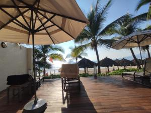 a deck with chairs and umbrellas on the beach at BVG Villa 1 Norte in Ixtapa