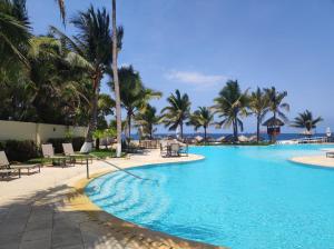 a pool at the resort with palm trees and chairs at BVG Villa 1 Norte in Ixtapa