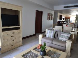 a living room with a couch and a tv at BVG Villa 1 Norte in Ixtapa
