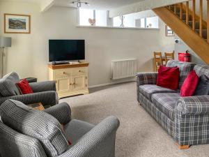 a living room with couches and a flat screen tv at The Chapel in Staveley