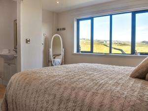a bedroom with a large bed and a large window at The Wolfs Den - Uk49083 in Winewall