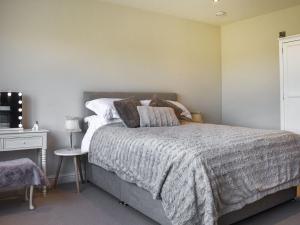 a bedroom with a bed and a dresser with a table at The Wolfs Den - Uk49083 in Winewall
