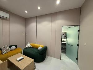 a living room with a green chair and a mirror at أجنحة هدوء وصول ذاتي in Medina