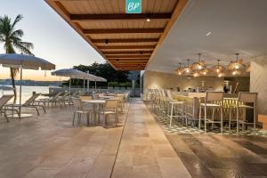 a restaurant with tables and chairs and a bar at PANAREA - Luxury Beachfront Condos in Bucerias in Bucerías