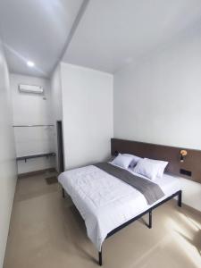 a bedroom with a bed in a white room at Hotel Sarijadi Pangururan in Pangururan