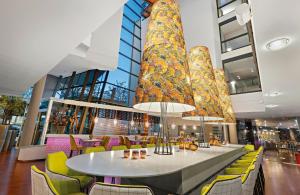 a dining room with a table and chairs in a building at Leonardo Hotel Esslingen in Esslingen