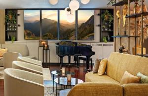 a living room with a couch and a grand piano at Leonardo Hotel Esslingen in Esslingen