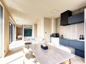a kitchen and living room with a table and chairs at Kandor Resort Okinawa in Nakijin