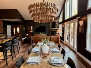 a dining room with a table and chairs and a chandelier at Elegant Blackwood Grove by Casa Oso in Mariposa