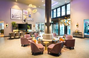 a lobby with chairs and a waiting room at Leonardo Hotel Eschborn Frankfurt in Eschborn +49 photos