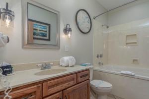 a bathroom with a sink and a toilet and a clock at 1BR Village At Indian Point 2102 near SDC-Free Tickets Daily up to $500 in Branson +14 photos