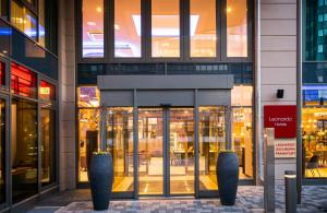 a building with a revolving door in a city at Leonardo Hotel Eschborn Frankfurt in Eschborn