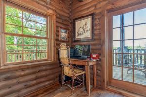 a computer desk in a log cabin with windows at 1BR Village At Indian Point 1104 near SDC-Free Tickets Daily up to $500 in Branson