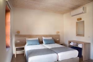 a bedroom with a large bed with blue pillows at C&M Residence Chania Old Town in Chania