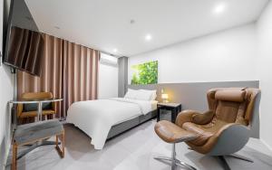 a hotel room with a bed and a chair at Songdo The Seoleim Hotel Stay in Incheon