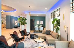a living room with a couch and chairs at Leonardo Hotel Hamburg Altona in Hamburg