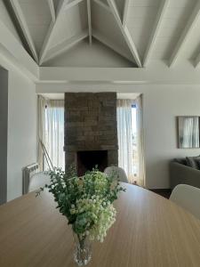 a vase of flowers on a table with a fireplace at Lenga Hogar in El Calafate +9 photos