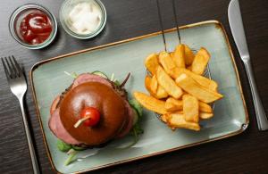 a plate of food with a sandwich and french fries at Leonardo Hotel Düsseldorf City Center in Düsseldorf +50 photos