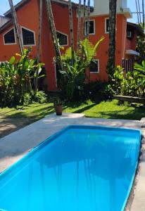 a blue swimming pool in front of a house at Studio8 Centro Paraty in Paraty