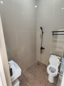 a bathroom with a toilet and a sink at Hotel Sarijadi Pangururan in Pangururan