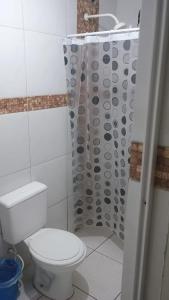 a bathroom with a toilet and a shower curtain at Ap do Jhone in Canoa Quebrada