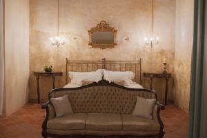 ein Bett mit einer Couch in einem Zimmer mit einem Spiegel in der Unterkunft Cien Sueños Hotel Boutique in Mérida + 82 Fotos