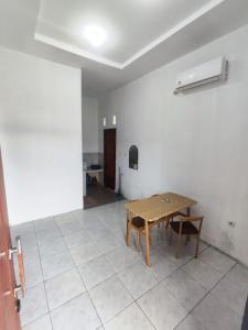 a room with a wooden table and a tiled floor at Hotel Sarijadi Pangururan in Pangururan +10 photos