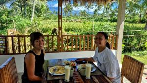 two women sitting at a table with food at Greenfield-Lombok in Tetebatu +15 photos