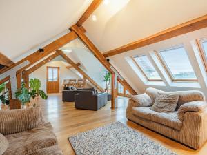 a living room with vaulted ceilings and skylights at The Barn At Whitefields in Walcot