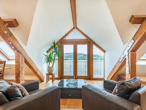 a living room with a couch and a table at The Barn At Whitefields in Walcot +22 photos