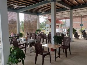 an outdoor patio with tables and chairs at New Land Hostel in Kaôh Rŭng (3) +21 photos