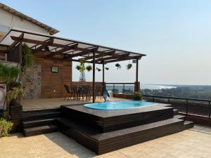 a patio with a pool and a table and chairs at Cobertura luxuosa Marambaia in Barra de Guaratiba