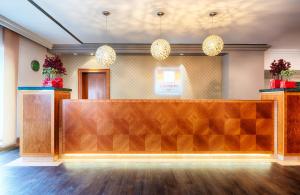 a reception desk in a lobby with pendant lights at Leonardo Hotel Heidelberg in Heidelberg