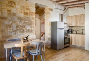 a kitchen with a refrigerator and a table with stools at C&M Residence Chania Old Town in Chania